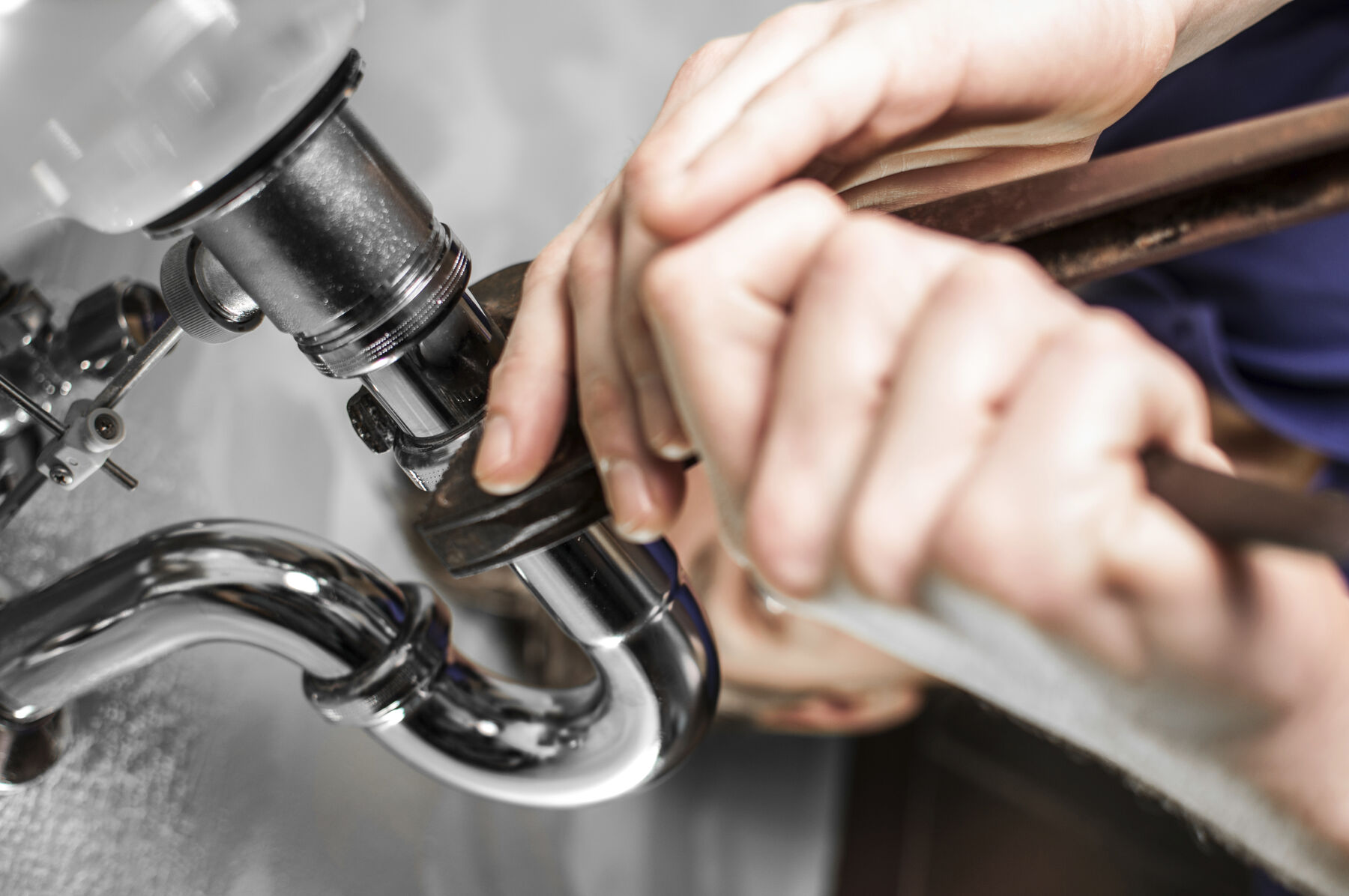 Plumber fixing a sink siphon
